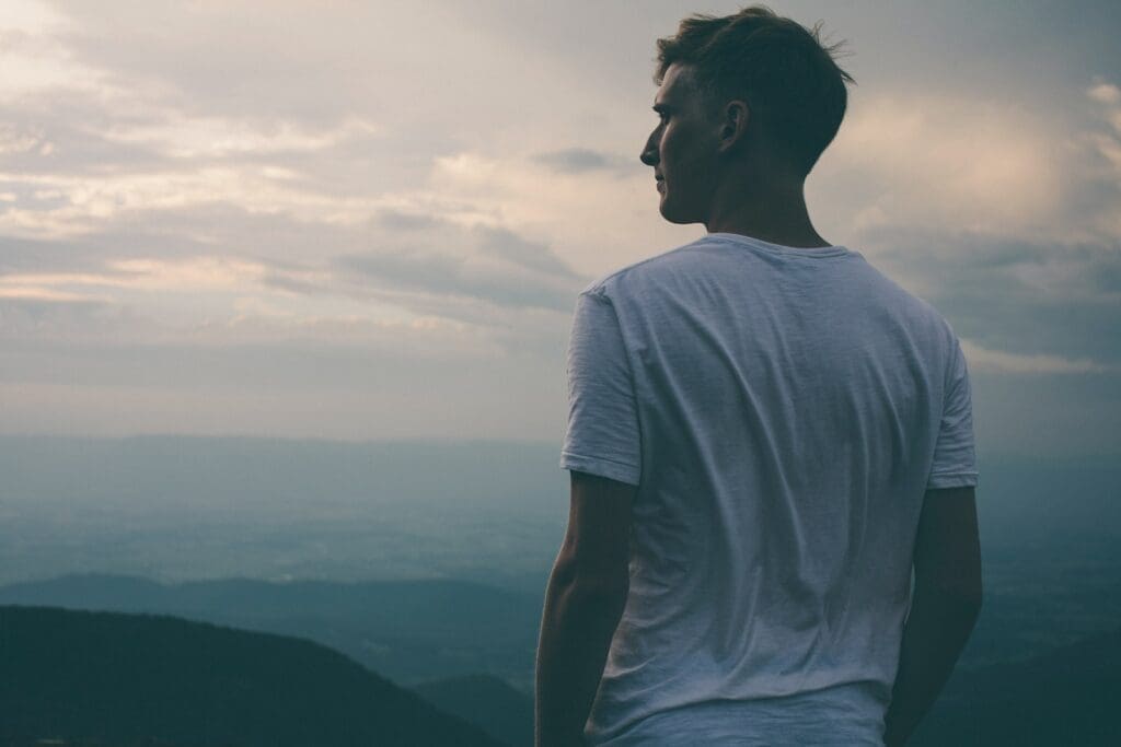 Top 10 Health Tips for Men to Adopt During Men's Health Week 2023: man standing facing mountains during sunset