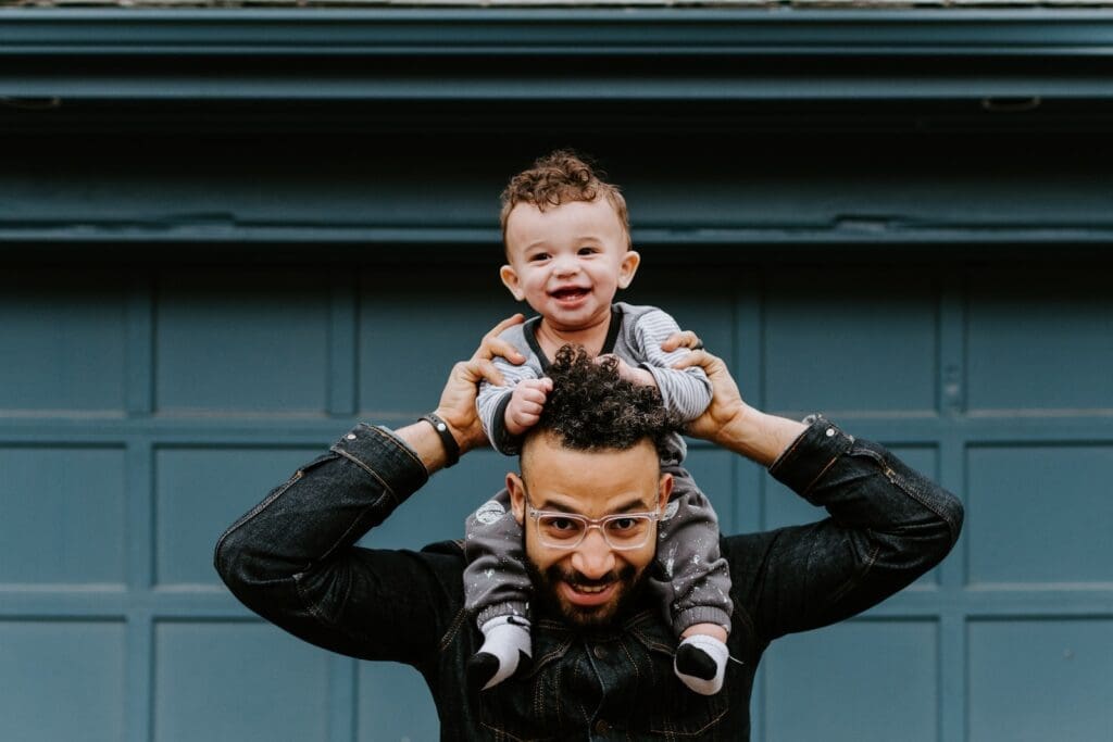 Roll of Fathers, man in black leather jacket carrying boy in black leather jacket